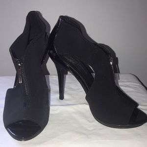 black patent peep toe shoe with 4 1/2” heel . Zip front neoprene type material .